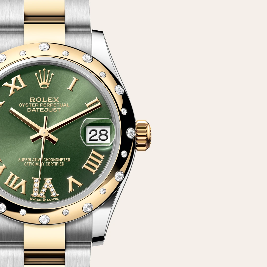 Close-up of a two-tone Rolex Datejust with green dial, diamond bezel, and date window showing 28. | Brela