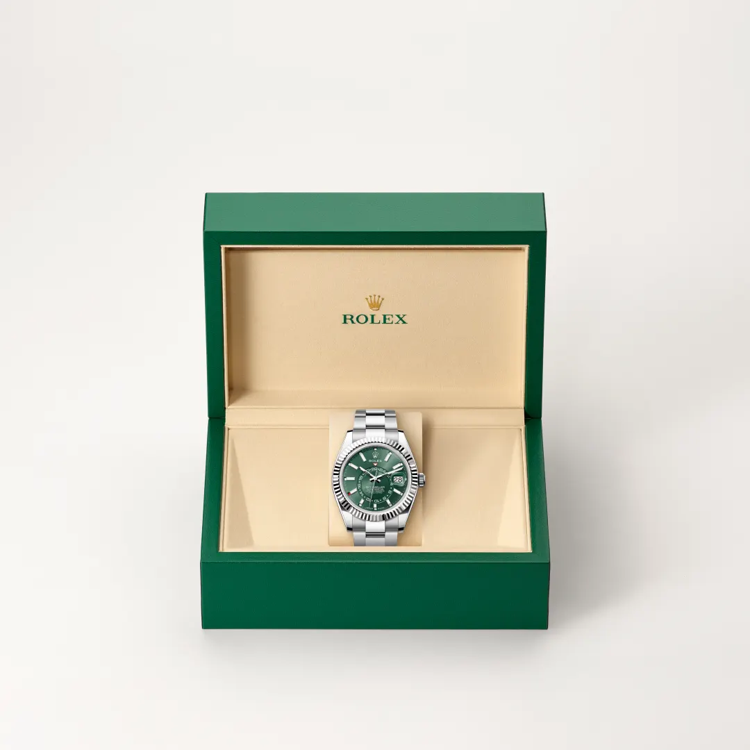 m336934-0001-slide2 | Brela Rolex watch with green dial in an open beige interior box, green outer case visible, luxury presentation photo | Brela
