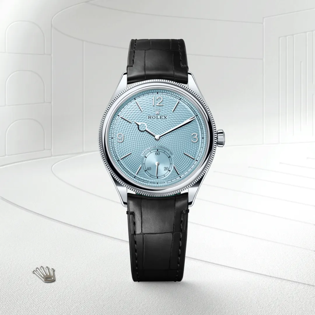 m52506-0003-slide1 | Brela Rolex wristwatch with a textured light-blue dial, silver hands, and a black leather strap. | Brela