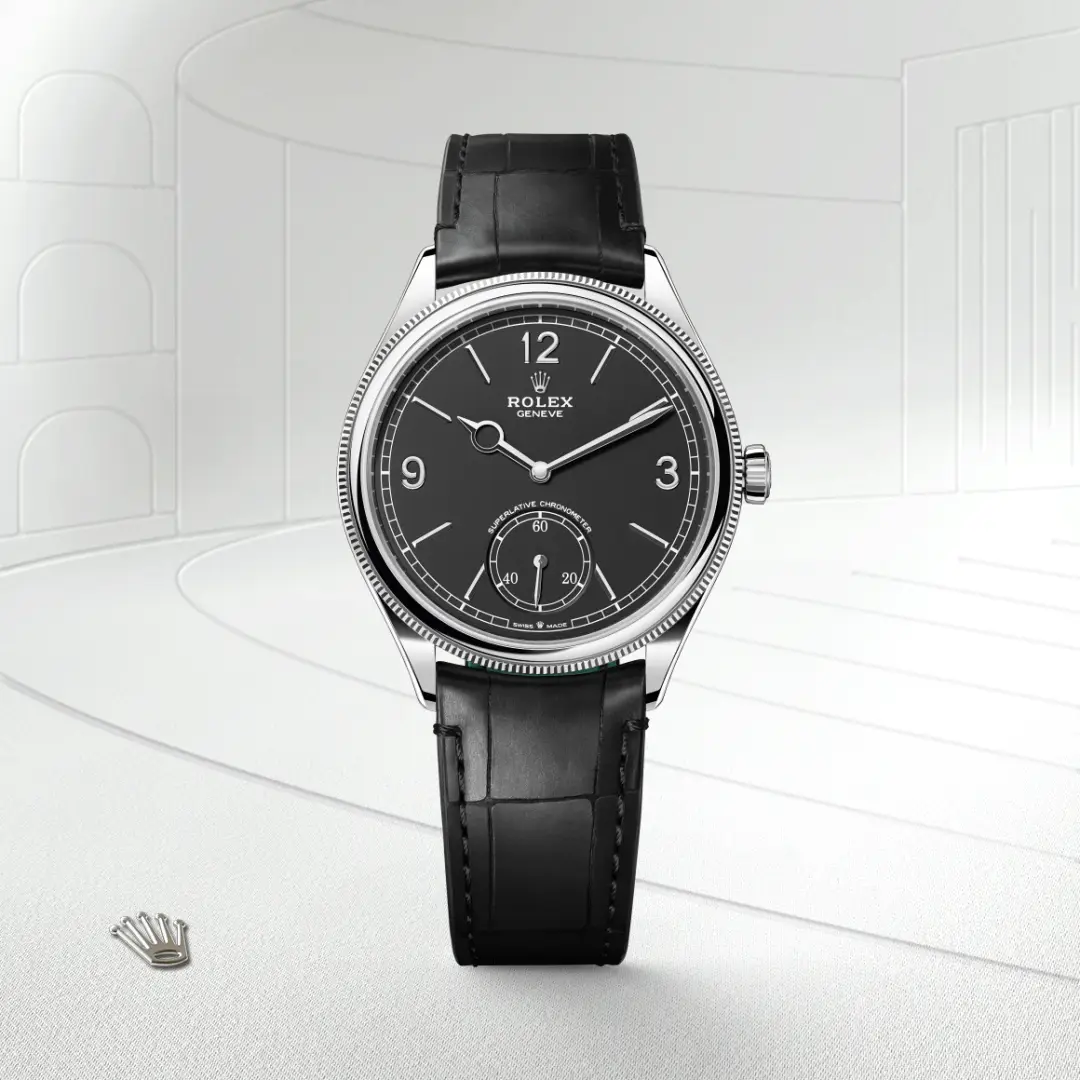 m52509-0002-slide1 | Brela Rolex wristwatch with a black dial, silver case, and black leather strap, showing time with a small seconds subdial at 6 o'clock. | Brela