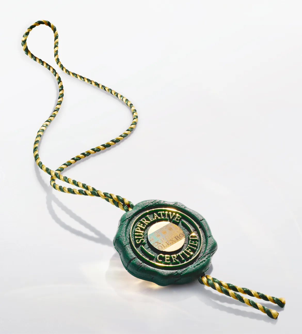 Green wax seal with gold lettering 'Superlative Certified' attached to a green-and-gold braided cord.
