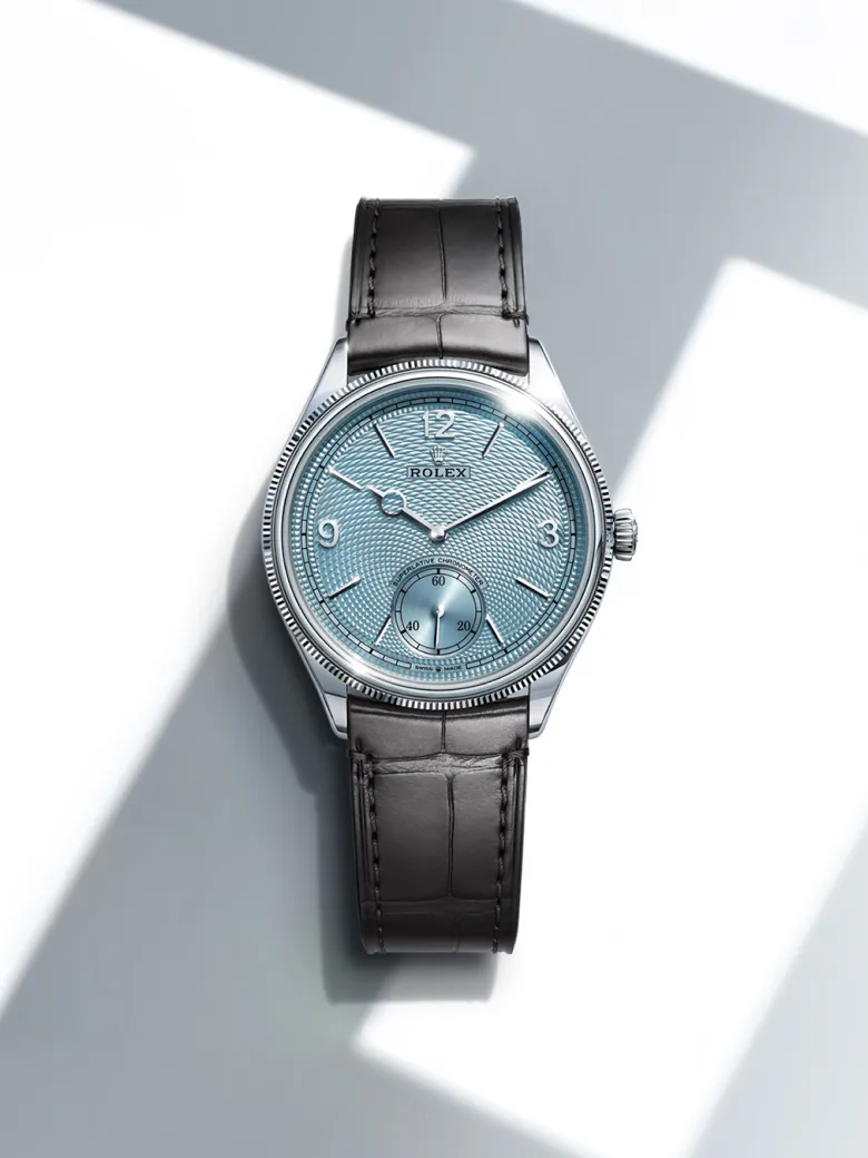 rolex-watches-1908-m52506-0002-portrait | Brela Luxury wristwatch with light blue textured dial and black leather strap, close-up shot showing silver case and crown. | Brela