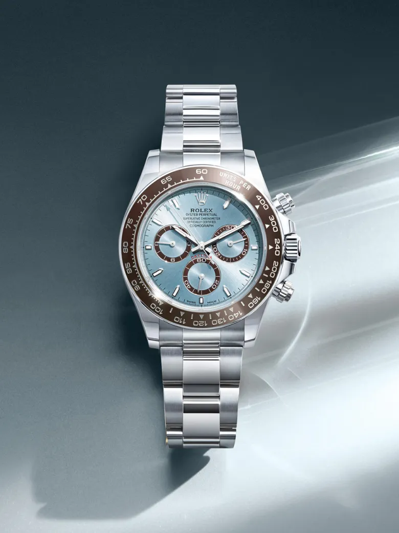 rolex-watches-cosmograph-daytona-m126506-0001-portrait | Brela Rolex Oyster Perpetual Cosmograph Daytona stainless steel watch with a light blue dial and brown bezel displayed against a dark background | Brela
