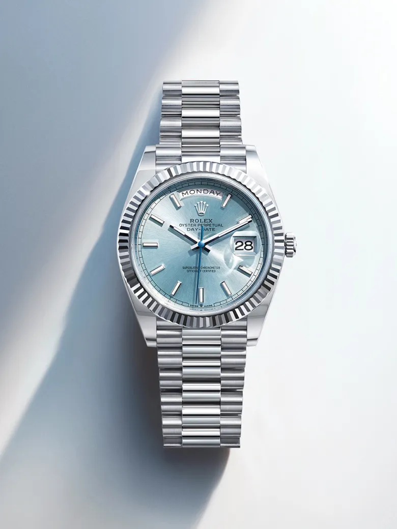 rolex-watches-day-date-m128236-0018-portrait | Brela Close-up of a silver Rolex Day-Date watch with a blue dial, displaying Monday and the date 28, on a stainless steel bracelet. | Brela