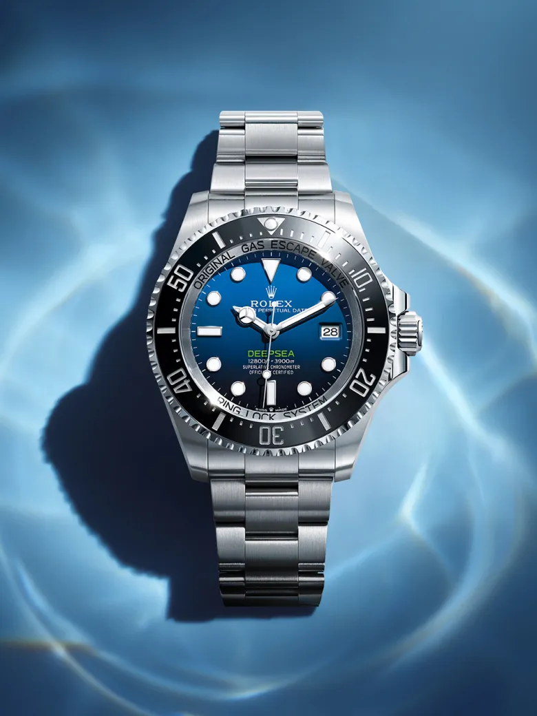 rolex-watches-deepsea-m136660-0005-portrait | Brela Rolex Deepsea stainless steel dive watch with blue dial, rotating bezel, and date window, photographed underwater backdrop. | Brela