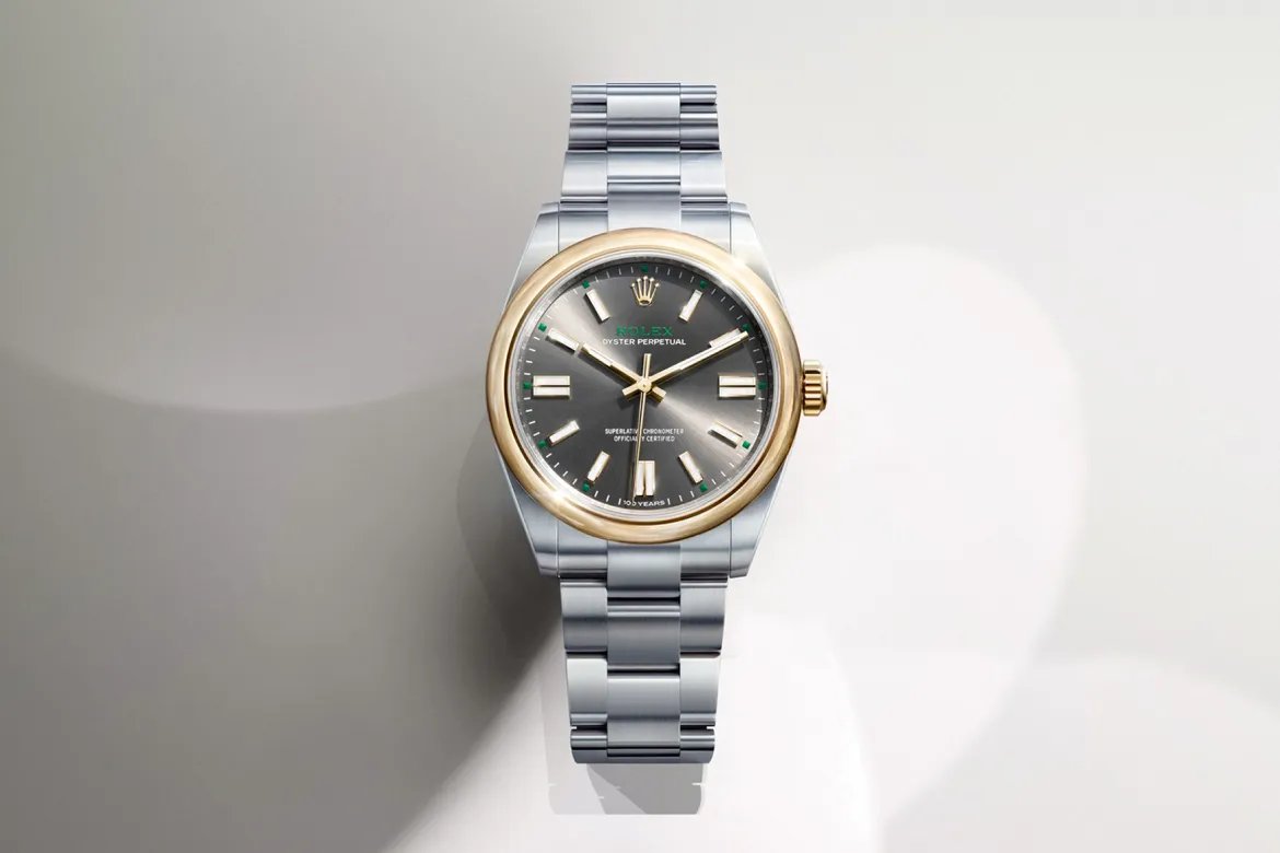 rolex-watches-oyster-perpetual-m134303-0001-landscape | Brela Rolex Oyster Perpetual wristwatch with a gold bezel and stainless steel bracelet on a light background. | Brela