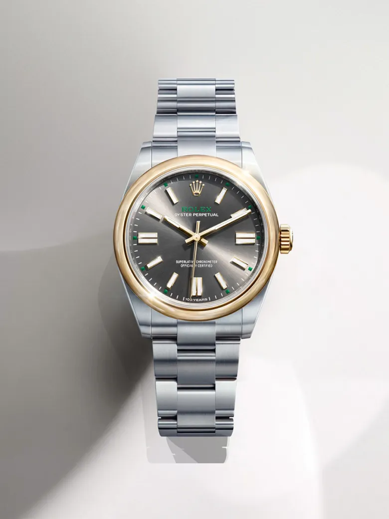 rolex-watches-oyster-perpetual-m134303-0001-portrait | Brela Rolex Oyster Perpetual wristwatch with a two-tone gold bezel and stainless steel bracelet, grey dial, and luminous markers. | Brela
