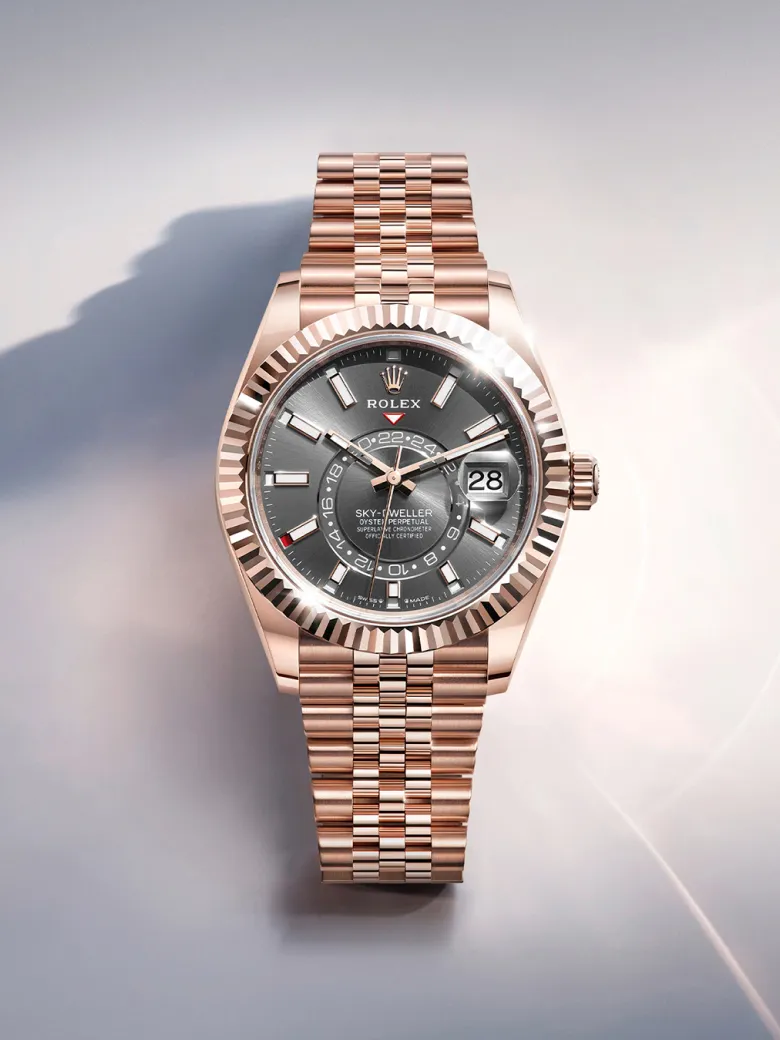 rolex-watches-sky-dweller-m336935-0008-portrait | Brela Rose gold Rolex Sky-Dweller wristwatch with fluted bezel, black dial, and date window at 3 o'clock. | Brela