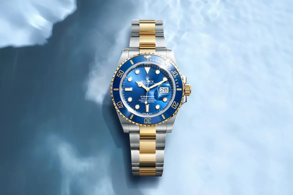 rolex-watches-submariner-m126613lb-0002-landscape | Brela Two-tone Rolex Submariner watch with blue dial and date window on a blue background. | Brela