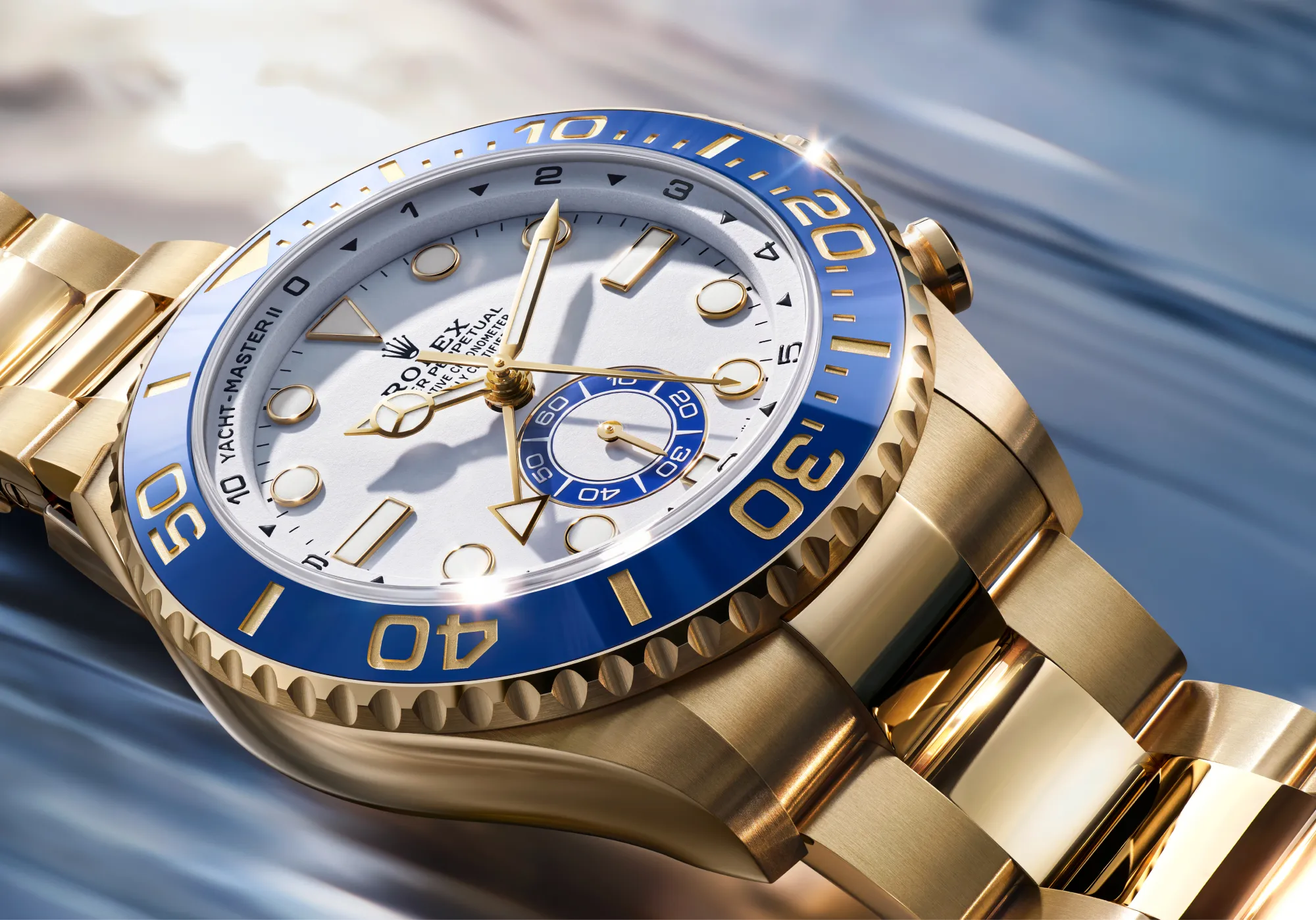 Close-up of a gold Rolex watch with a blue bezel and white dial, showing intricate markers and hands.