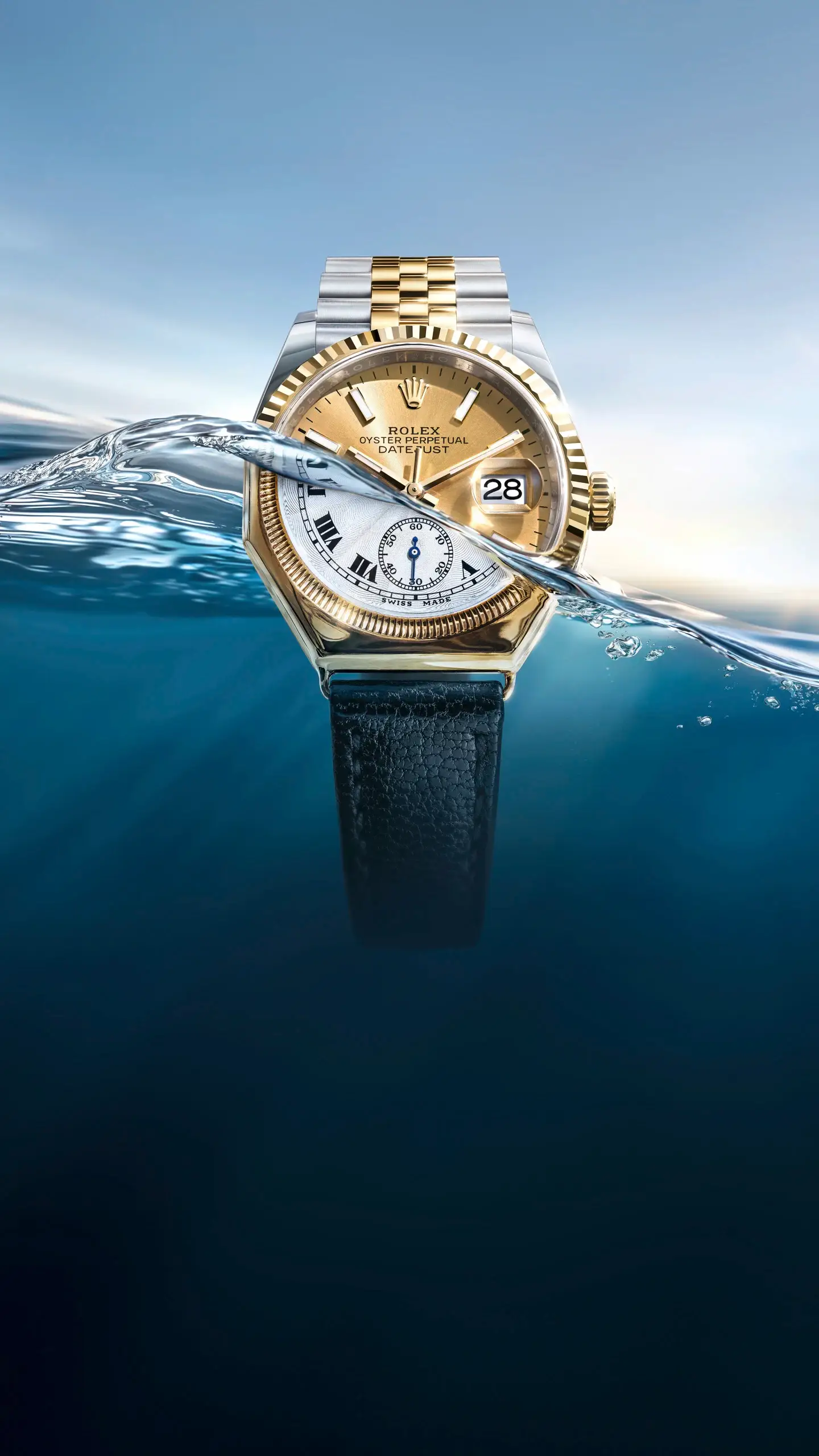 Two-tone Rolex Datejust wristwatch with gold dial and steel-gold bracelet, partially submerged with water splashing around it.