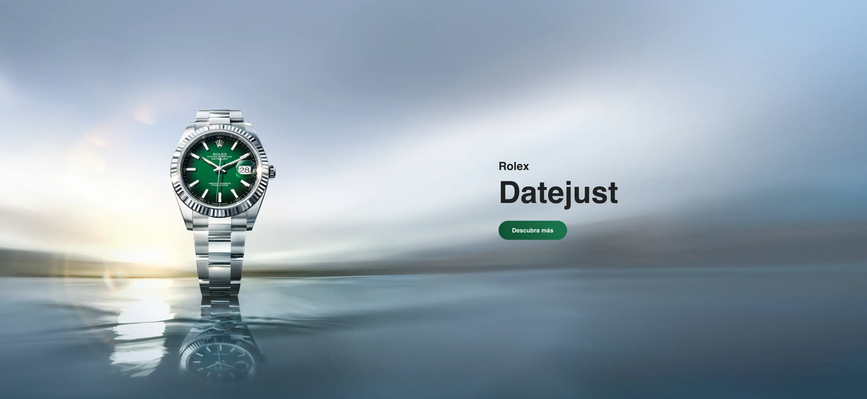Rolex Datejust advertisement showing a stainless steel watch with a green dial on the left and a 'Descubra más' button on the right over a blue sky and water background.