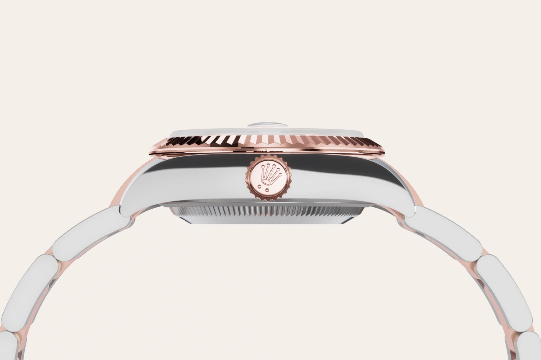 Side view of a two-tone Rolex wristwatch with rose-gold bezel, crown, and links against a light background. | Brela