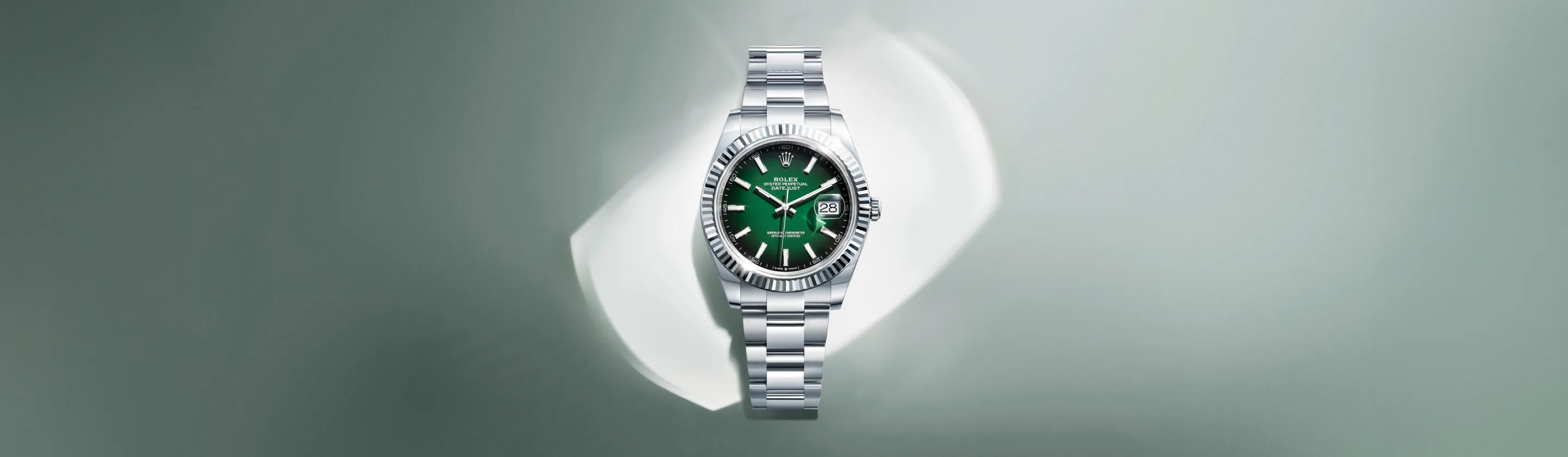 rolex-datejust-cover-m126334-0033-landscape Green-dial Rolex Datejust with silver stainless steel bracelet on a soft gray background.
