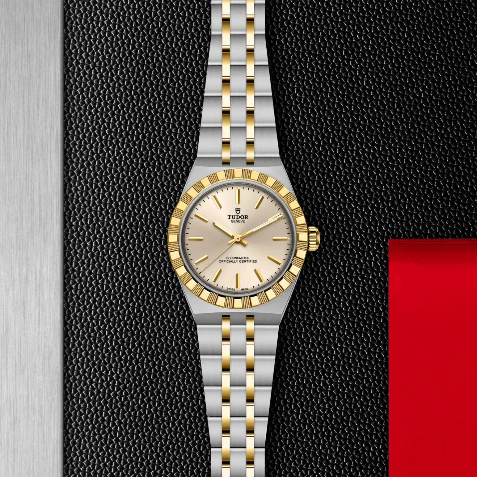 m2830a1a3-0003in_store_flat_lay | Brela Two-tone Tudor wristwatch with a gold bezel and bracelet on a textured black surface. | Brela