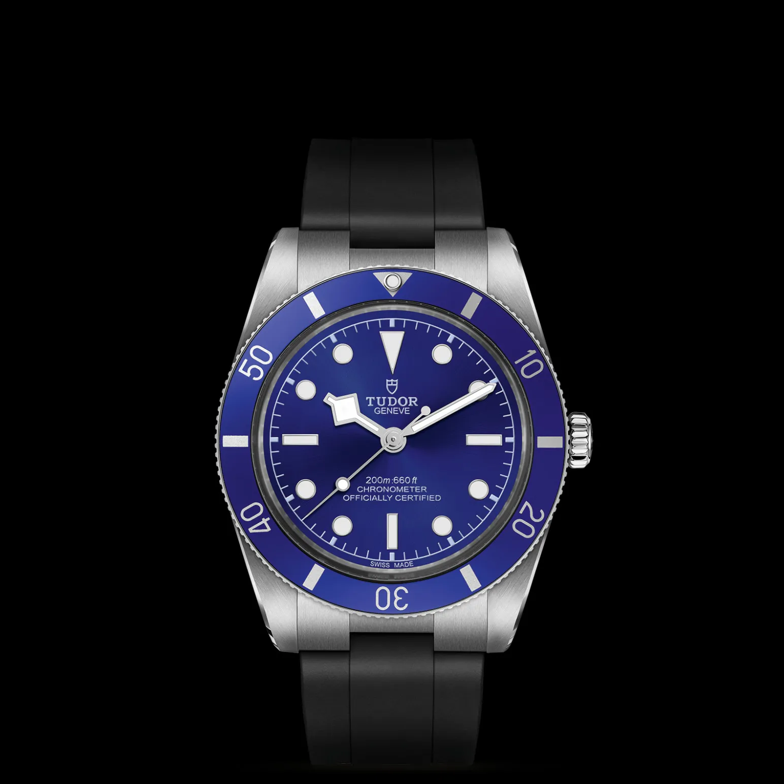 m79000b-0002-upright_watch_black_background_zoomed_in | Brela Tudor Genève blue-dial diver watch with a blue bezel, stainless steel case, and black strap from a bottom-front view | Brela