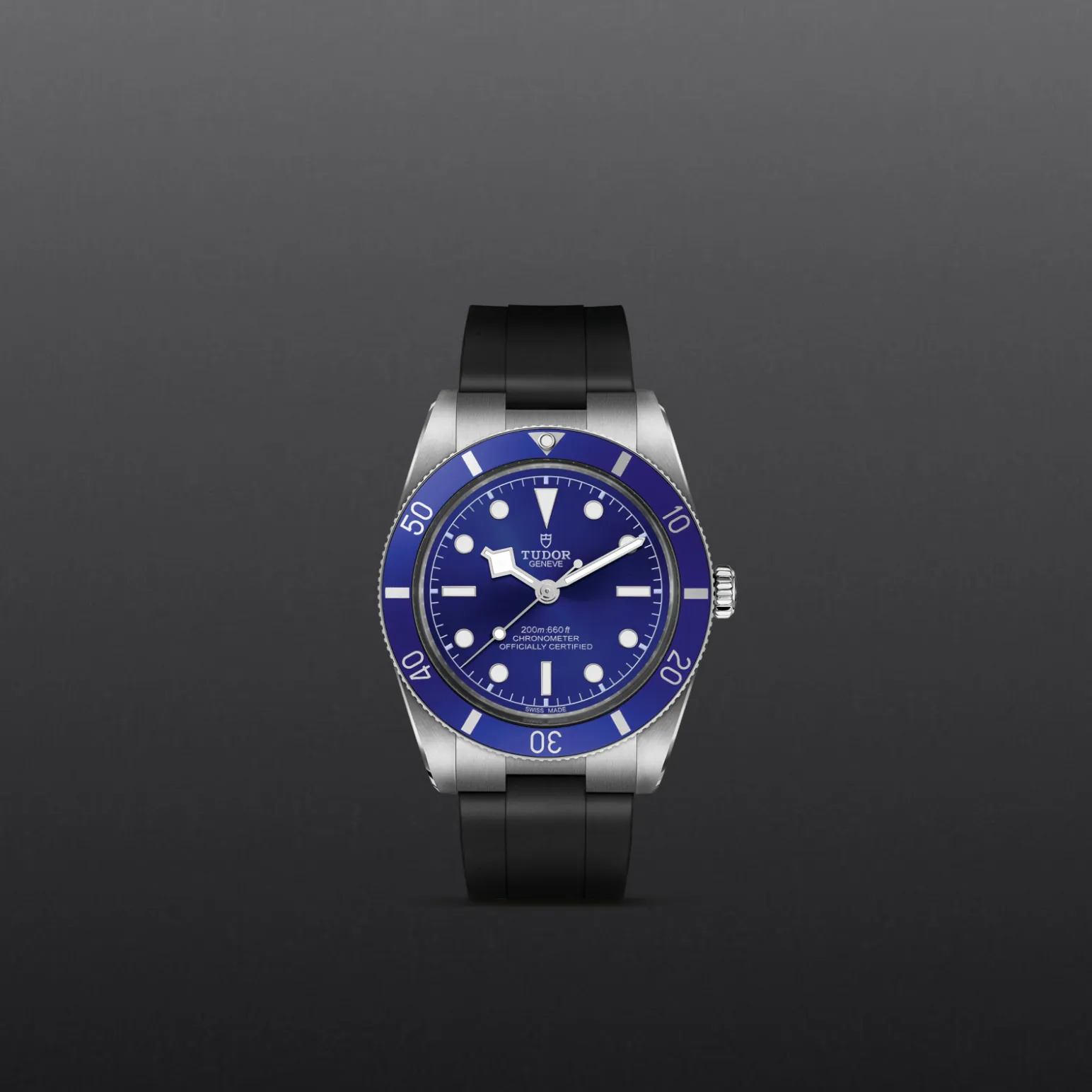 m79000b-0002-upright_watch_grey_background-model_page_only_standard_size | Brela Blue-dial Tudor diver's watch with blue bezel and stainless steel case on a black strap, centered against a gray gradient background. | Brela