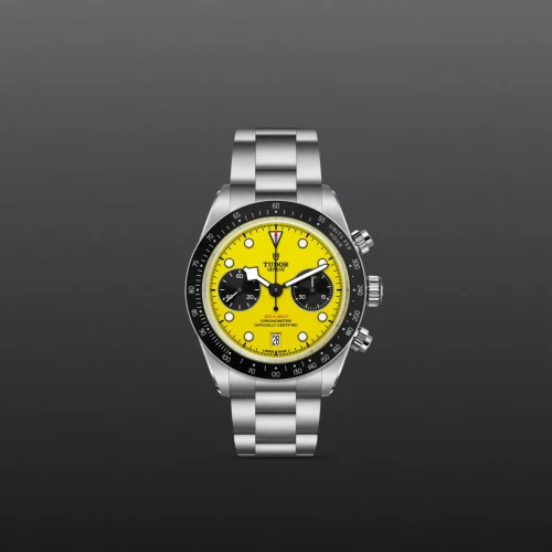 Stainless steel Tudor chronograph watch with a bright yellow dial and black subdials against a dark gray background
