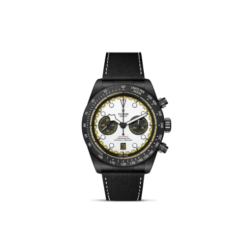 Black Tudor chronograph watch with white dial, yellow accents, and black strap; multiple subdials and date window visible.
