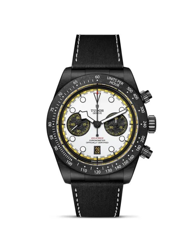 m79377kn-0003_upright-wh-std-grid | Brela | Brela Tudor chronograph wristwatch with white dial, black bezel, yellow accent ring, and black leather strap. | Brela | Brela