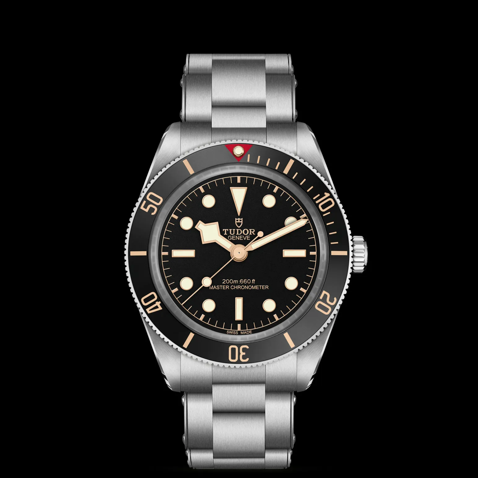 m7939a1a0nu-0002-upright_watch_black_background_zoomed_in | Brela Close-up of a Tudor diving watch with a black dial, gold markers and bezel, stainless steel bracelet, against a black background | Brela