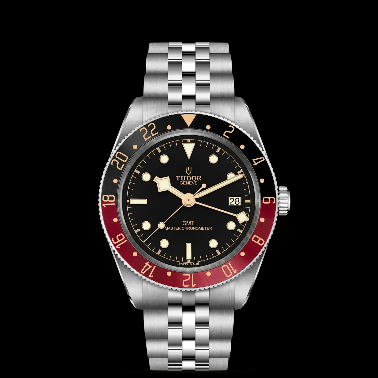 m7939g1a0nru-0003-upright_watch_black_background_zoomed_in | Brela Tudor GMT Master watch with black dial, red/black bezel, and steel bracelet showing date at 3 o'clock on a black background | Brela