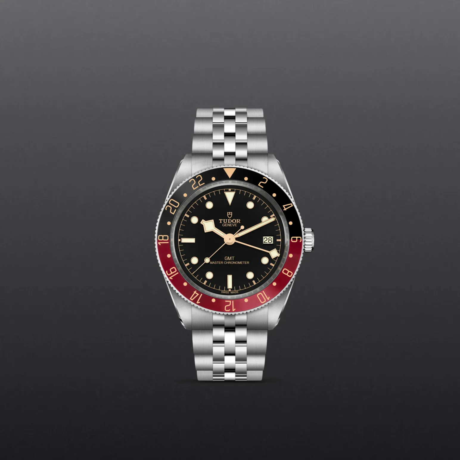 m7939g1a0nru-0003-upright_watch_grey_background-model_page_only_standard_size | Brela Close-up of a stainless steel Tudor GMT Master chronometer watch with a red/black bezel, black dial, and date window on a gray background. | Brela