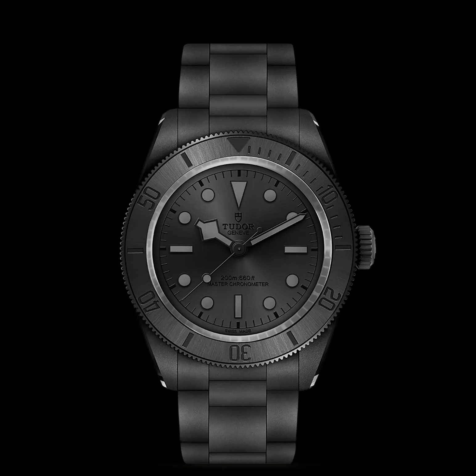 m7941a1acnu-0001-upright_watch_black_background_zoomed_in | Brela Close-up of a black Tudor wristwatch with a metal bracelet and rotating bezel on a black background, highlighting the dark dial and markers. | Brela