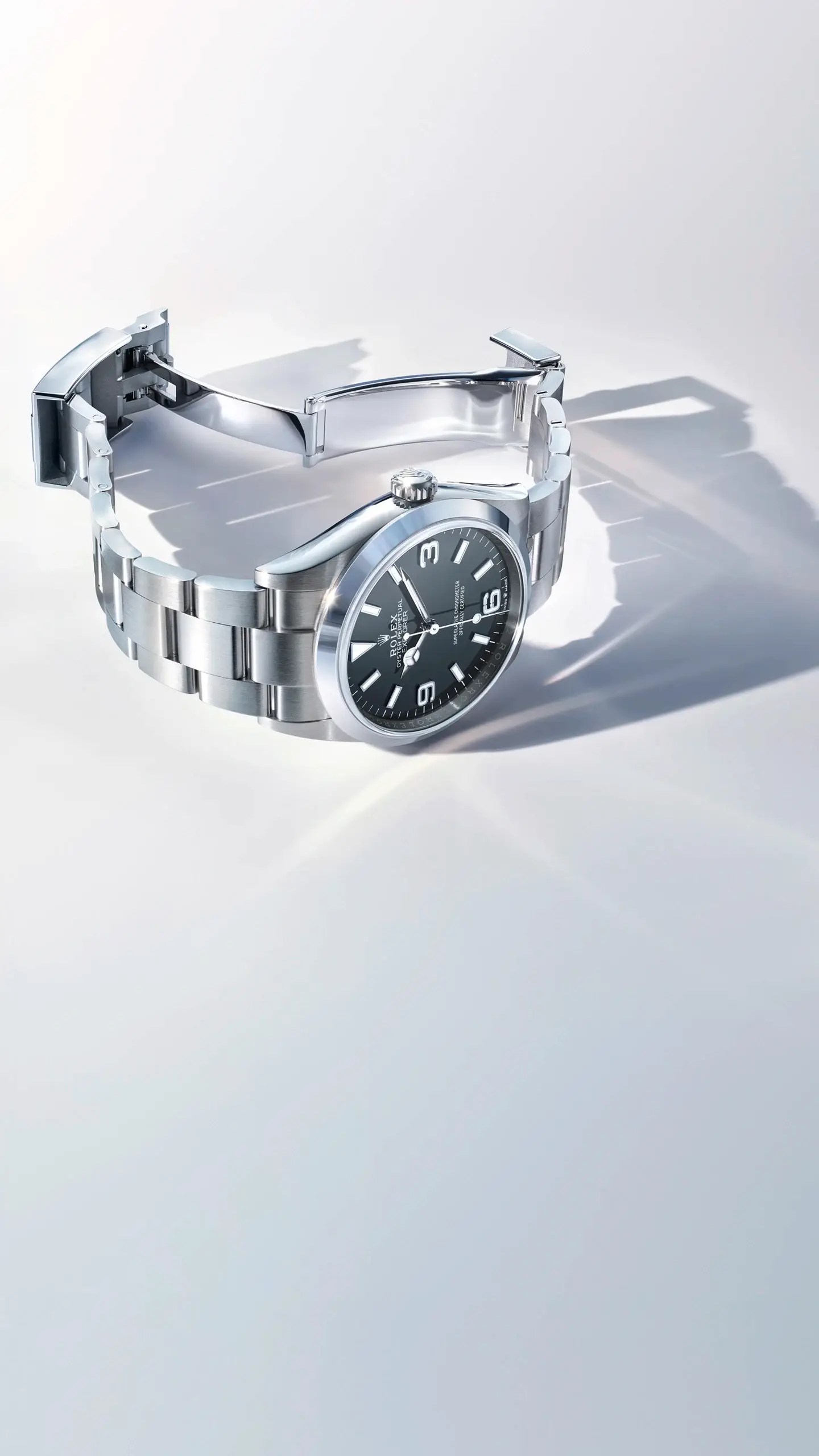 Stainless steel wristwatch with a black dial and white numerals on a light, glossy surface.