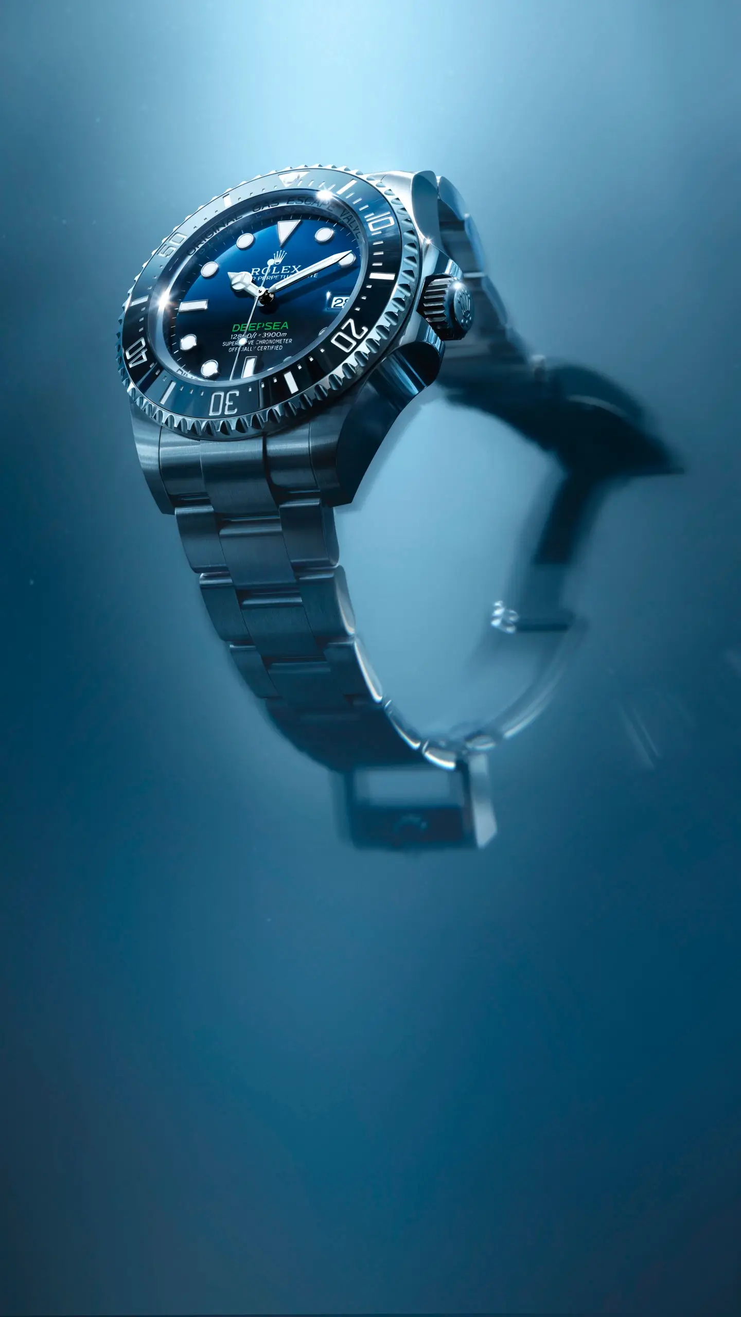 Close-up of a stainless steel Rolex Deepsea dive watch underwater, blue dial and rotating bezel