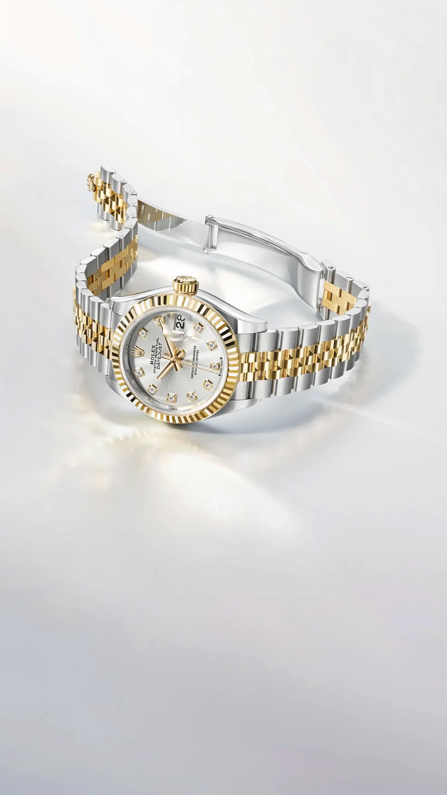 Two-tone gold and stainless steel Rolex Datejust with diamond hour markers and a fluted bezel, shown on a light background.